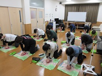 指導員が模擬キットを使用して心肺蘇生の練習をしています。