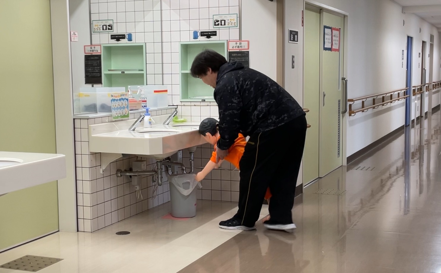 舎生（人形）が洗面所に頭を強打しています。