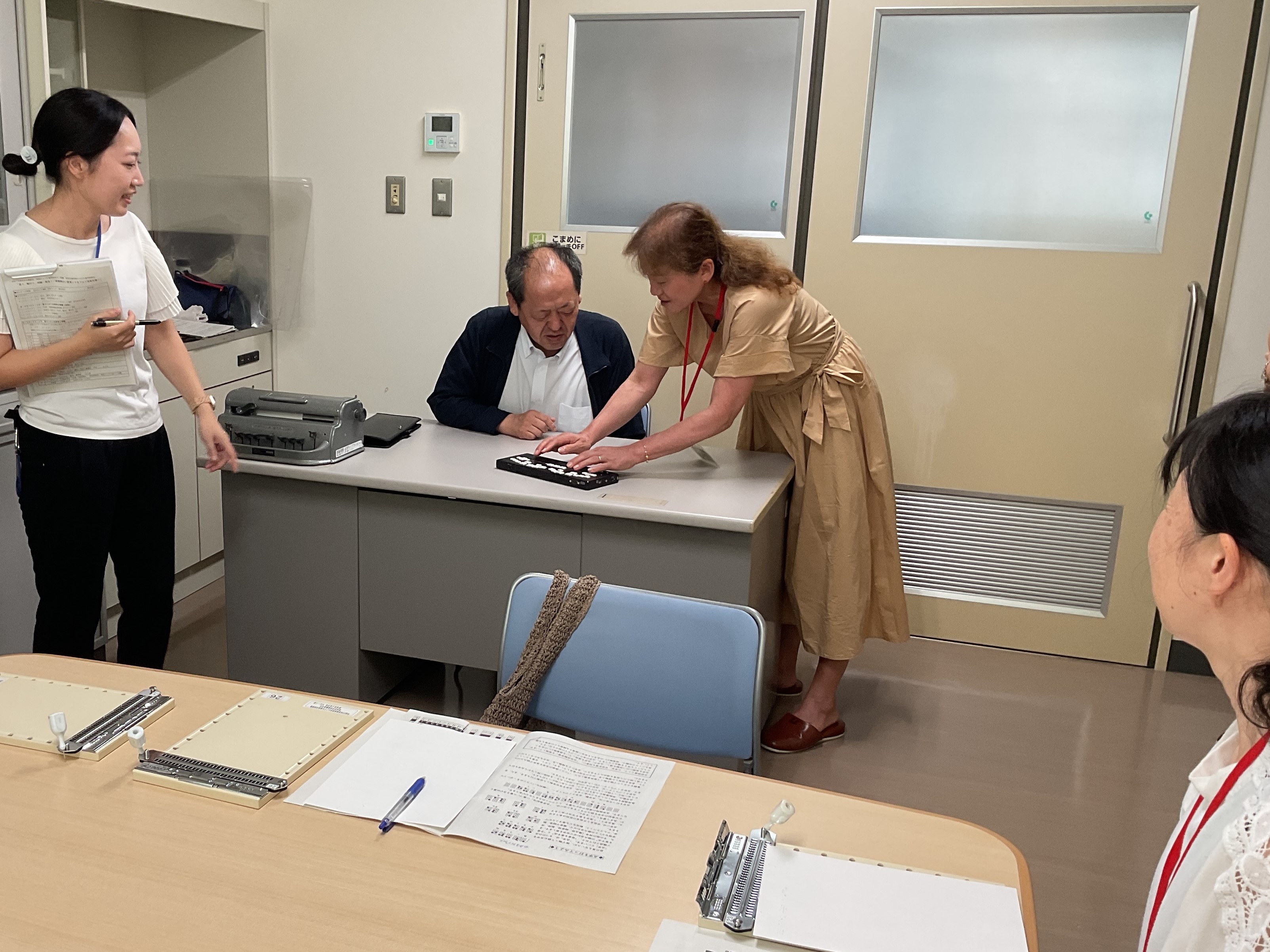 参加者が点字タイプライターで点字を打つ体験をしている様子