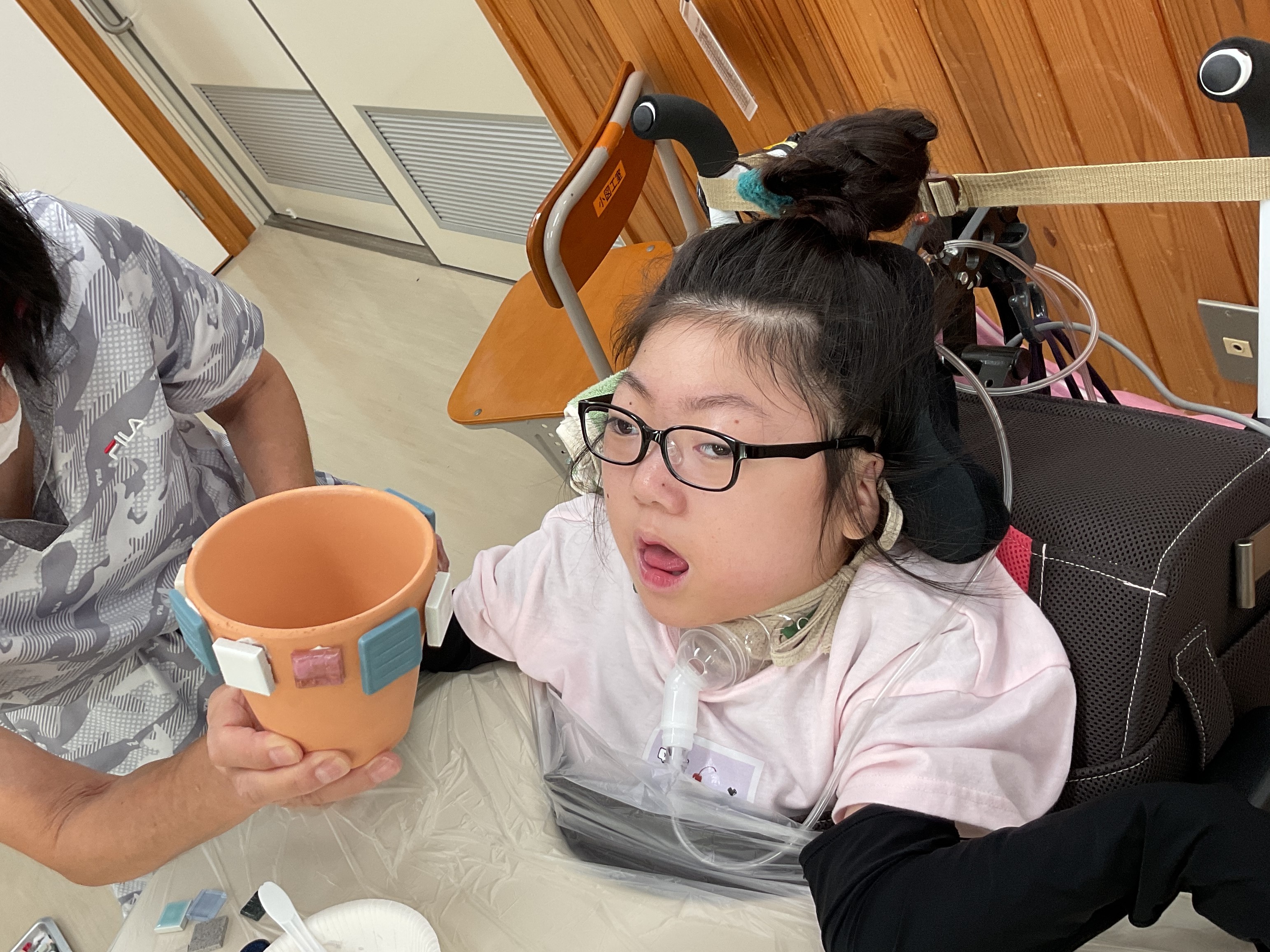 児童が植木鉢にタイルを貼っている様子