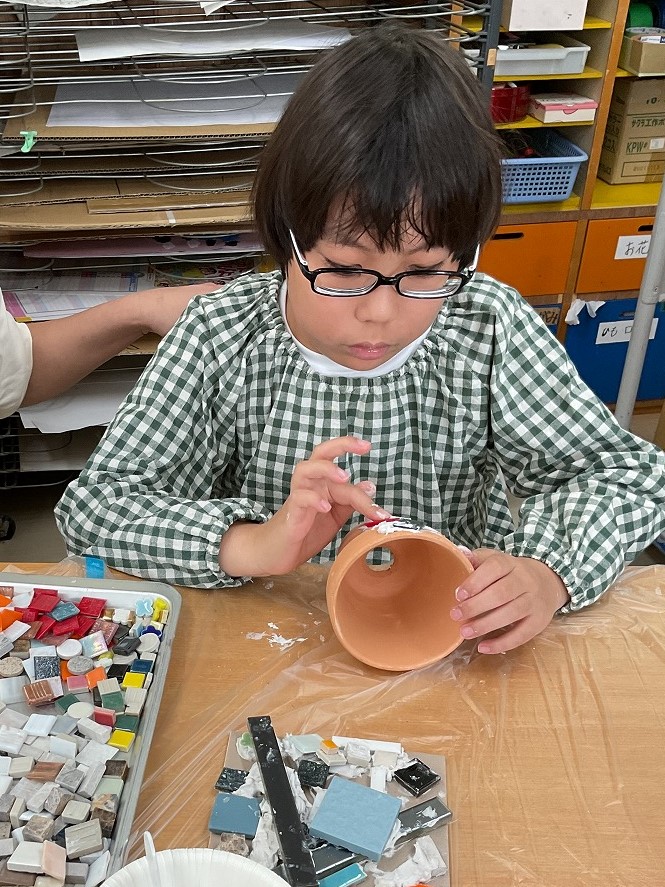 児童が植木鉢にタイルを貼り合わせている様子
