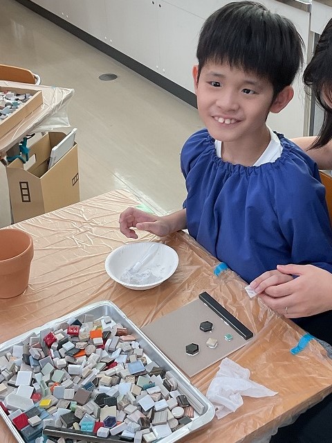 児童がコースターにタイルを貼っている様子