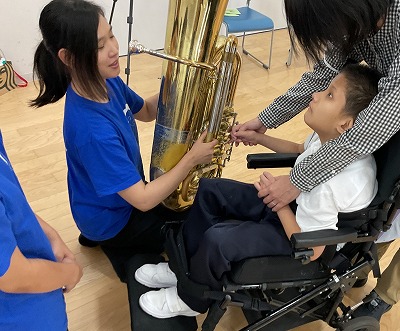 中学部の生徒がチューバの楽器を観察している写真