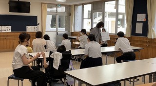 守ることが書かれたボードを生徒が読んでいる写真。