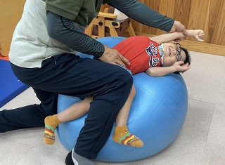 ボールの上で側臥位になり、右腕を伸ばし中
