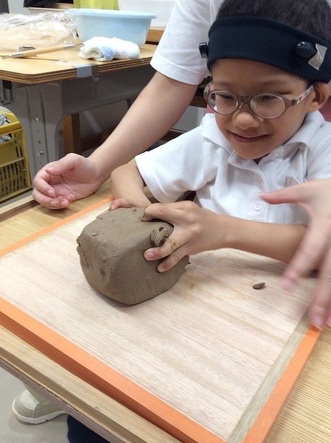 袋から土ねんどを出して喜ぶ児童