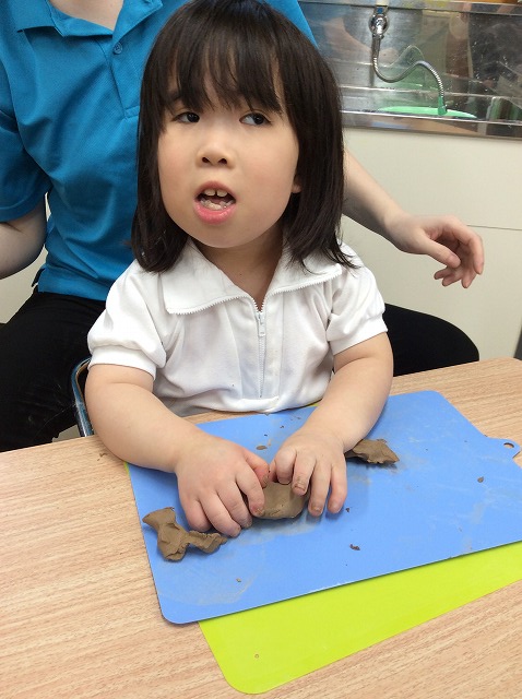 歌いながらこねたりちぎったりしている児童