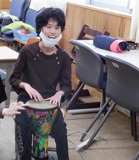 生徒が笑顔でジャンベをたたいています