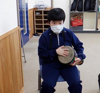 生徒がジャンベを腕に抱きかかえたたいています