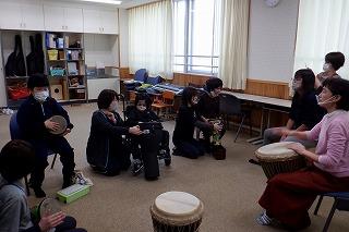 みんなでジャンベをたたいて合奏しています