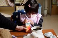 パックのジュースにストローをさす生徒