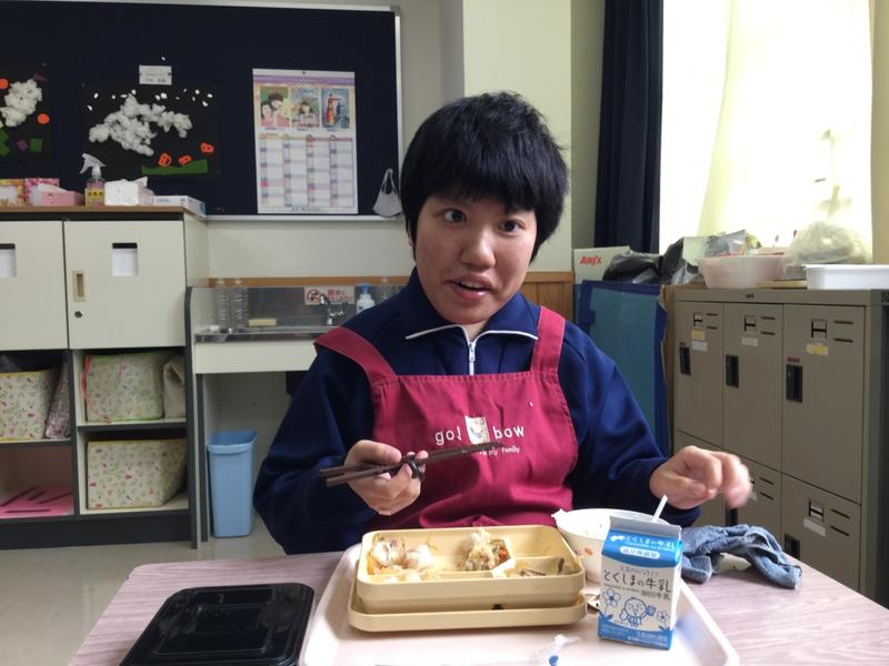 笑顔で給食を食べる生徒