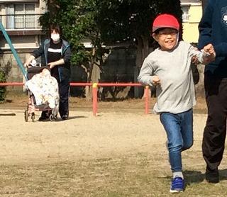 教員と一緒に児童が走っている写真。
