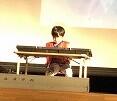 ステージでキーボードを弾いている写真。