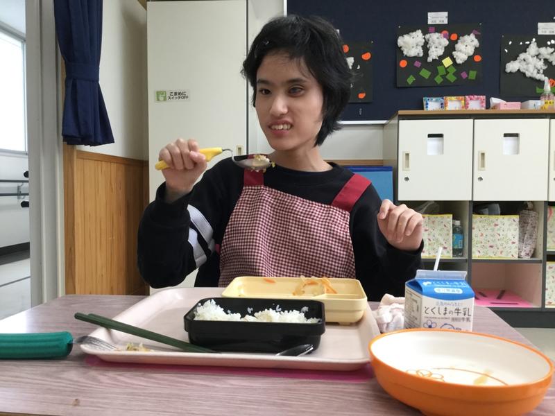 笑顔で給食を食べる生徒